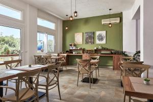 a restaurant with tables and chairs and green walls at Charm Hotel, Hersonissos in Hersonissos