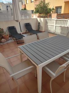una mesa de madera y sillas en un patio en Vistamar II, en Cabo Roig