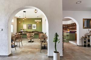 ヘルソニソスにあるCharm Hotel, Hersonissosのアーチ道、テーブル、椅子のあるレストラン