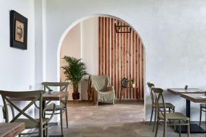a dining room with tables and chairs and an archway at Charm Hotel, Hersonissos in Hersonissos