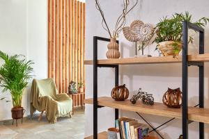 a room with shelves with plants and a chair at Charm Hotel, Hersonissos in Hersonissos