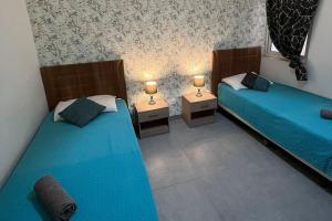 two beds in a room with two lamps on them at Serenity Sea-view Maisonette in Marsalforn