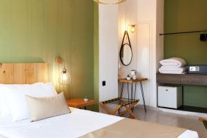 a bedroom with a white bed and green walls at Charm Hotel, Hersonissos in Hersonissos