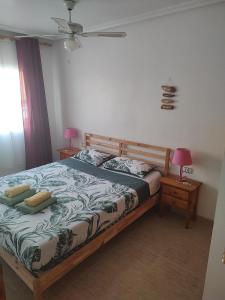 1 dormitorio con 1 cama y 2 mesitas de noche con lámparas en Vistamar II, en Cabo Roig