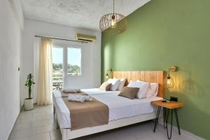 een slaapkamer met een groot bed met een groene muur bij Charm Hotel, Hersonissos in Chersonissos