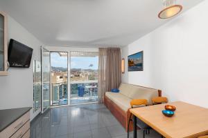 sala de estar con sofá, mesa y balcón en Apartaments Blau, en Lloret de Mar