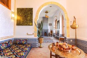 ein Wohnzimmer mit einem Sofa und einem Tisch in der Unterkunft Riad Villa with Mediterranean Sea Views of Spain and Gibraltar in Tangier