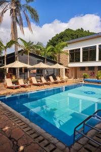 a pool with chairs and umbrellas next to a building at Aero Club of East Africa in Nairobi