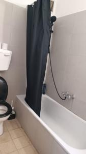 a bathroom with a shower with a black shower curtain at דירת אירוח בית שיאים in Beer Sheva