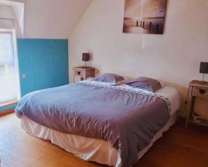 a bedroom with a bed and a painting on the wall at Maison en pierre au milieu du bocage in Coulouvray-Boisbenâtre