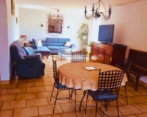 a living room with a table and chairs and a couch at Maison en pierre au milieu du bocage in Coulouvray-Boisbenâtre