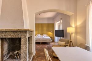 a hotel room with a bed and a fireplace at Mas Cusi in Palau-Saverdera