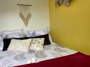 uma cama com almofadas num quarto em LE GAUGUIN, T2 Cosy, 2-4 Pers, à 300m des plages em Clohars-Carnoët