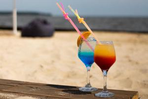 two drinks sitting on a table at the beach at Morewell in Tolokun