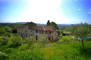 an old house on a hill in a green field at AGRITURISMO LUCESTRAIA in Montecatini Val di Cecina
