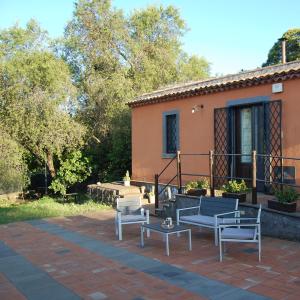 un patio con sillas y una mesa frente a una casa en La casa di Bacco - Etna Country House - Affitto breve, en Castiglione di Sicilia