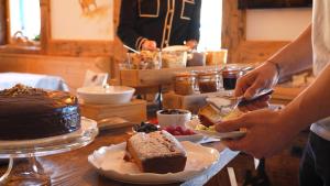 a person cutting a piece of cake on a table at BB le Fontanelle in Carano