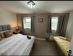 羅切斯特的住宿－San Pedro - Flagship Lodge，一间卧室设有一张大床和两个窗户。