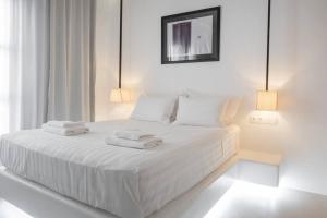 a white bedroom with a white bed with towels on it at Luxury Apartment Center of Mykonos Town - Sleeps 3 in Mýkonos City