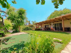 a house with a grass yard in front of it at Galilee Best Location in ‘En Dor