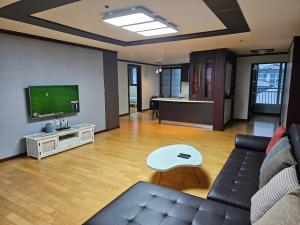 a living room with a couch and a flat screen tv at Dongtan Sharp-2 Family House in Hwaseong