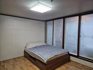 een slaapkamer met een bed in een kamer met ramen bij Dongtan Sharp-2 Family House 