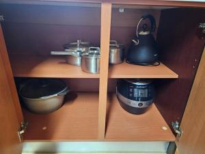 a wooden cabinet with pots and pans and a coffee maker at Dongtan Sharp-2 Family House in Hwaseong +28 photos