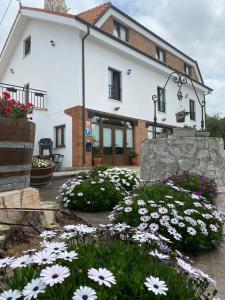 a white house with flowers in front of it at El Pradón in Mar