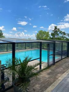 a view from the balcony of a house with a swimming pool at Ferme restaurée de vacance in Xaintrailles