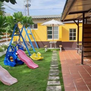 a backyard with a playground with slides and an umbrella at Hai Po Homestay in Checheng