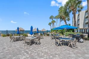 a patio with tables and chairs and blue umbrellas at Stunning Bay Views from your Private Balcony in Tampa