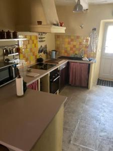 a kitchen with a sink and a stove top oven at Maison a Rustrel (A coté du Colorado Provençal ) in Rustrel