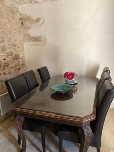 a table with chairs and a bowl of flowers on it at Maison a Rustrel (A coté du Colorado Provençal ) in Rustrel