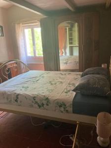 a large bed in a room with a mirror at Maison a Rustrel (A coté du Colorado Provençal ) in Rustrel