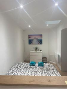 a bedroom with a large bed with two blue cushions at LESLIELOU T2 in La Ciotat