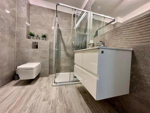 La salle de bains est pourvue d'une douche, d'un lavabo et de toilettes. dans l'établissement Apartament Pogorzelica - Baltic Park, à Pogorzelica