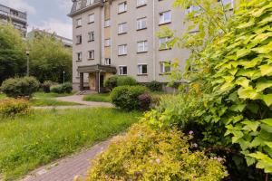 a garden in front of a building at Spacious & Quiet 1 Bedroom Apartment in Pruszków by Renters in Pruszków