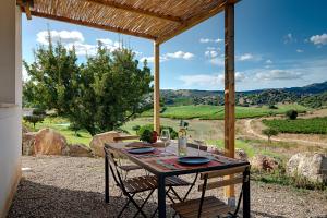 una mesa y sillas en un patio con vistas en Auberge Santu Martine: Cottage with pool (Pira), en Galtellì