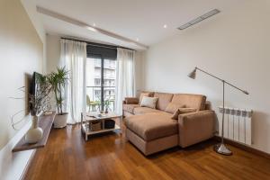 sala de estar con sofá y TV en Les Corts Exclusive Apartments by Olala Homes en Barcelona