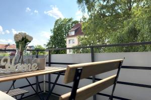 a balcony with a wooden table and a vase of flowers at Work & Stay Apartment with Balcony in Osnabrück