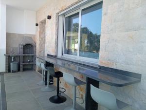 a bar with chairs and a window in a room at Villa Luz 37 - Jacuzzi Terrace & Swimming Pool in Albufeira
