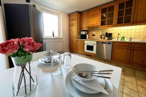 a kitchen with a table with a vase of roses on it at Work & Stay Apartment with Balcony in Osnabrück