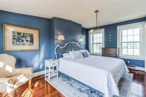a blue bedroom with a bed and a chair at Historic Petersburg Row Home in Petersburg