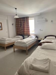 een kamer met 3 bedden en een raam bij AY OTEL 2 in Antalya