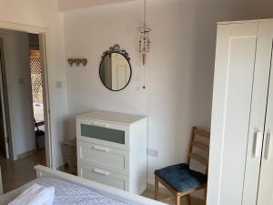 une chambre avec une commode et un miroir au mur dans l'établissement Little Blue House, à Sidari