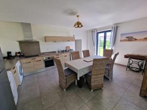 une cuisine avec une table et des chaises dans l'établissement Le Canteloup, à Saint-Caprais-de-Bordeaux