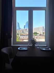 Qiz Galasi Hotel Baku في باكو: طاولة مع كأسين من النبيذ أمام النافذة