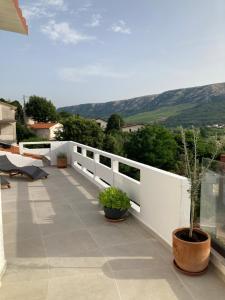a balcony with a white fence and potted plants at Apartments Nora & Lucija in Baška