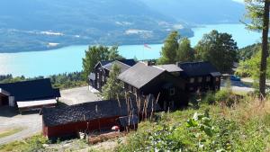 a house on the side of a hill with a lake at Glomstad Gjestehus in Tretten