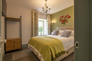 sypialnia z łóżkiem z żółtym kocem i oknem w obiekcie 3 Mill Cottages w mieście Ravensworth